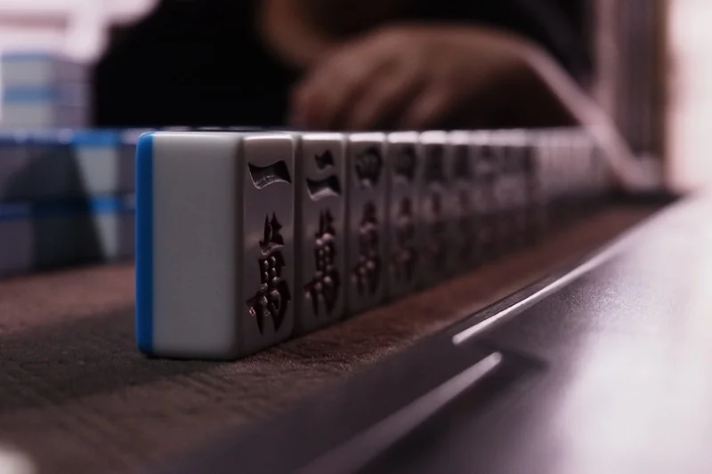 Mahjong tiles arranged on a wooden surface.